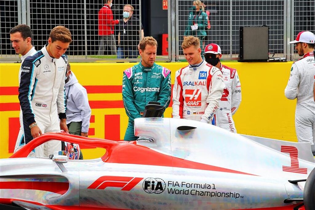 Mick Schumacher and Sebastian Vettel inspect the 2022 F1 car.v1